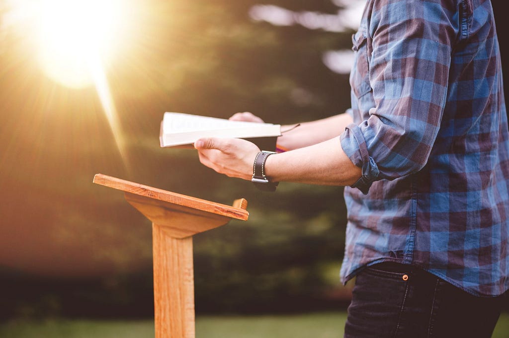 a photo of a man reading the Bible to instruct the ignorant