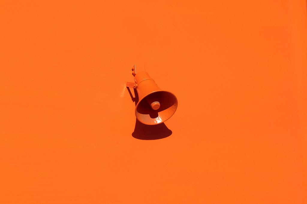 Orange megaphone on orange wall