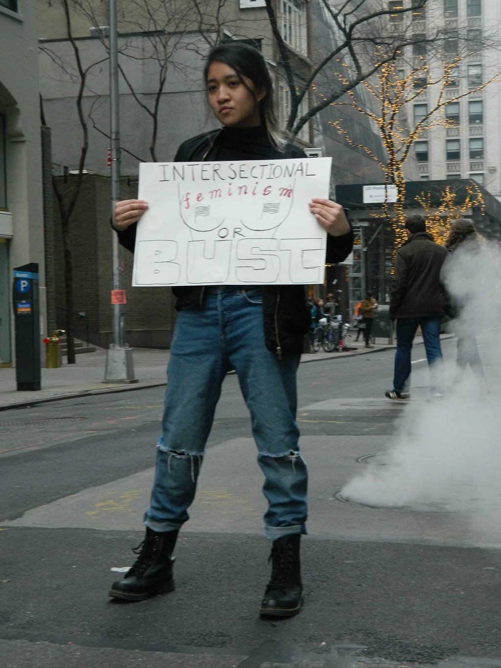 Thria Bernabe holds an “Intersectional feminism or bust” sign at the 2017 Women’s March in NYC.