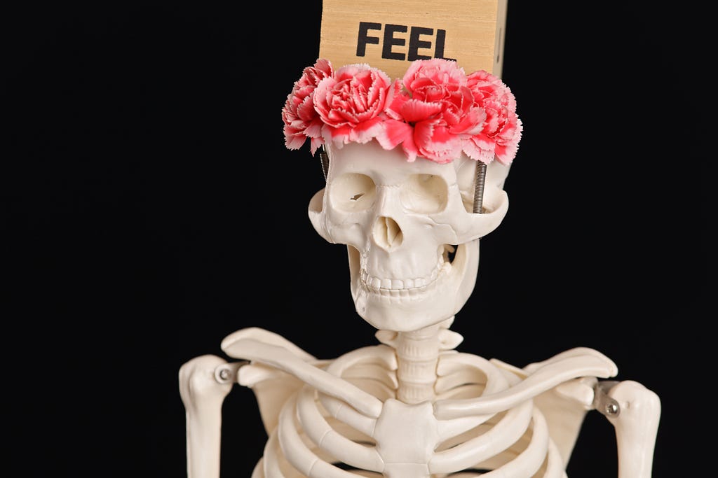Feeling Emotionally Numb, Depression concept; skeleton with pink flowers headband and feel text on top of skull