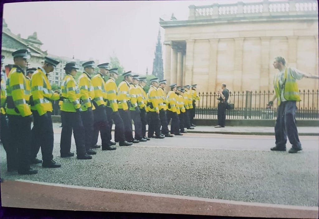 A lone reclaim the streets supporter stands defiant against a row of police officers. The mound, Edinburgh 2000/2001