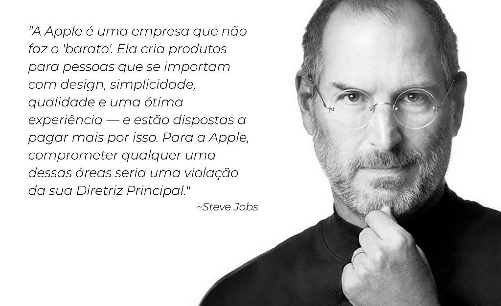 Foto icônica de Steve Jobs em preto e branco. Steve veste uma blusa de gola alta preta e seus óculos redondos de aro fino e prateado. Na imagem ele olha para a camera, seu olhar é expressivo e fixo na camera, e sua mão está no queixo indicando que ele está pensando em algo.