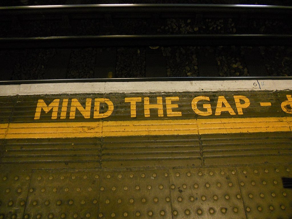 The ubiquitous “mind the gap” sign in yellow paint on concrete