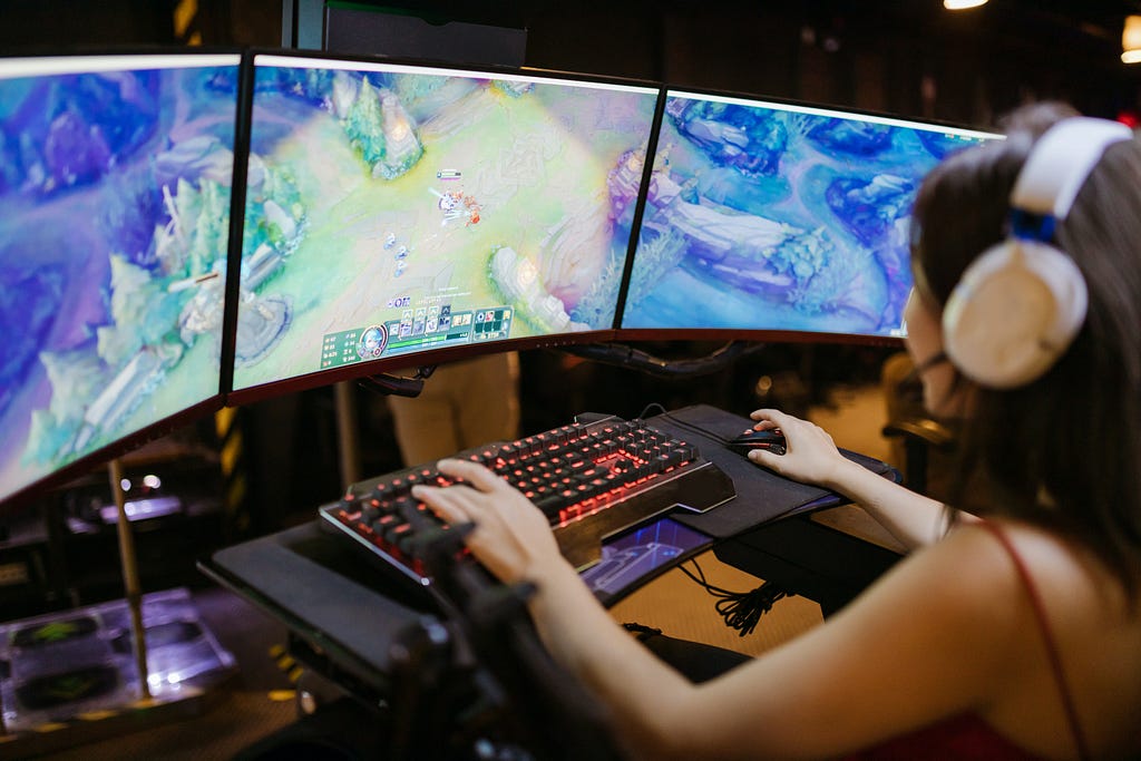 A young women playing a PC Game with a wide large multi screen in a gaming pro setting