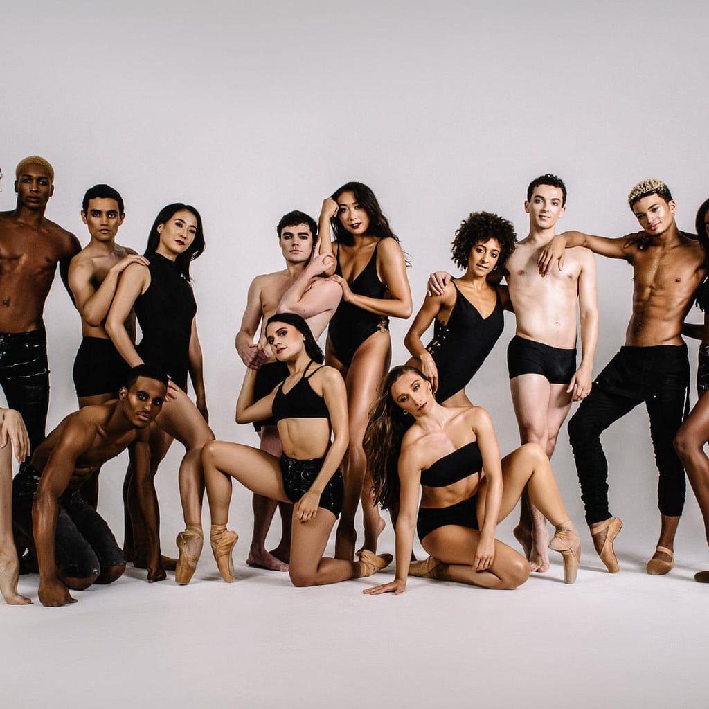 Group of eleven diverse dancers both standing and on the ground
