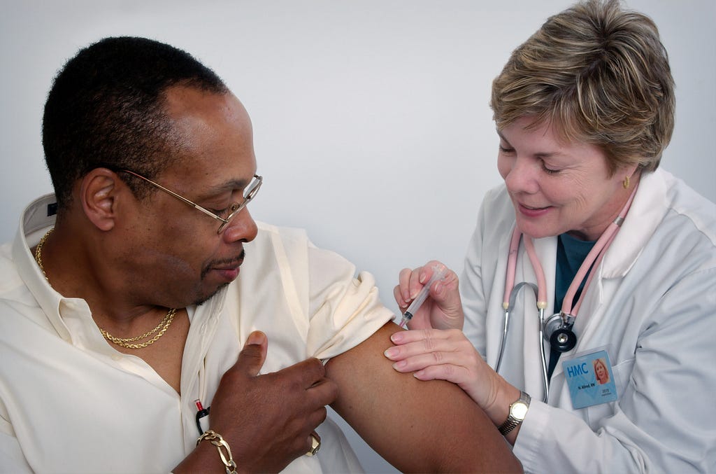 Man gets an vaccine from a medical professional.