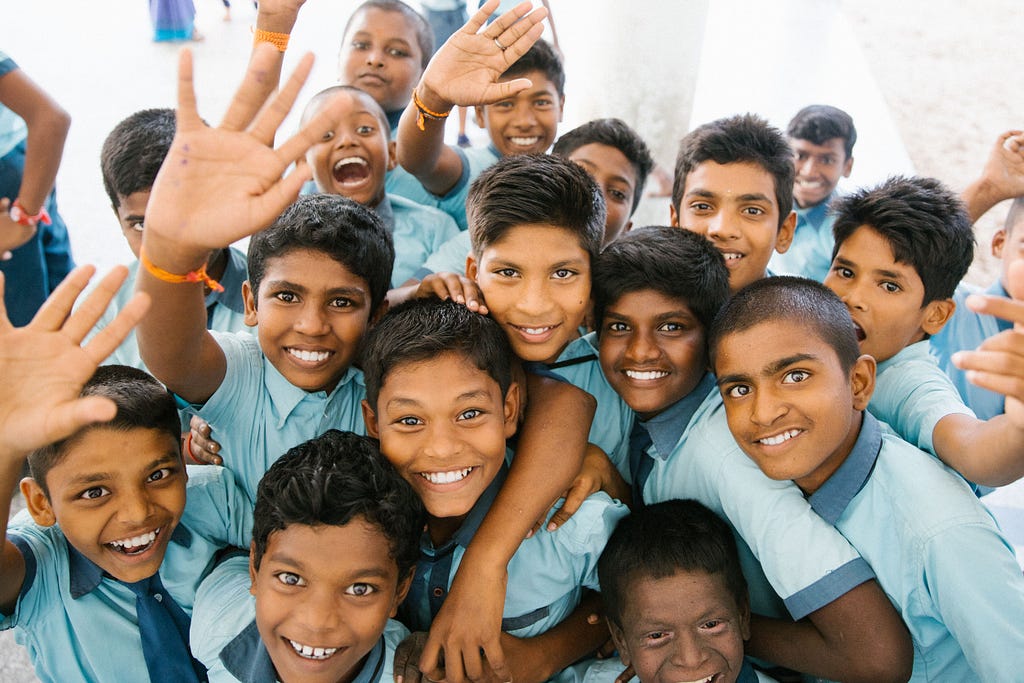 Indian school children waving up at the camera