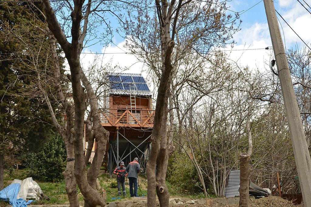 people constructing elevated wood cabin