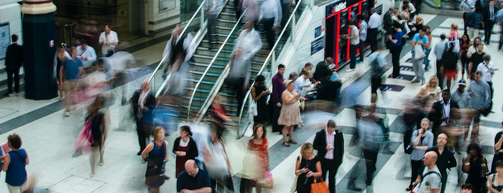 Picture of people moving through a London Tube Station, with motion blur.