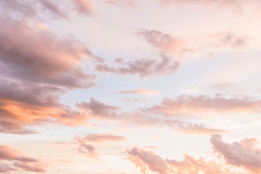 White cloud formations in a pink sky