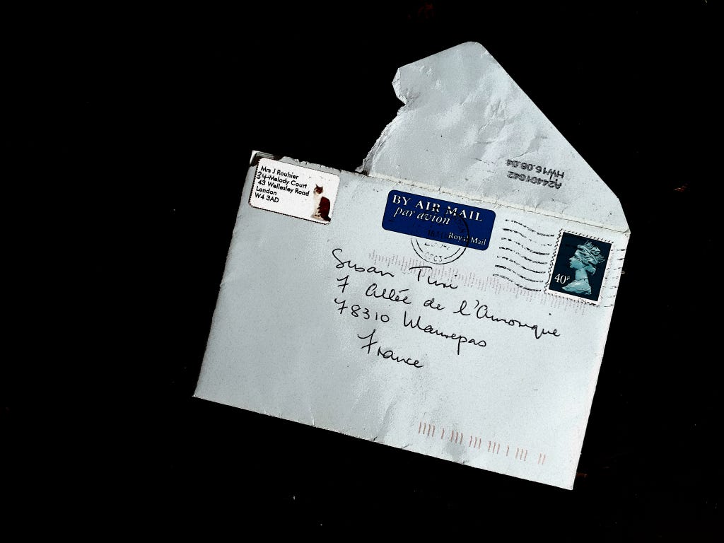 An open white envelope with an address from France on it.