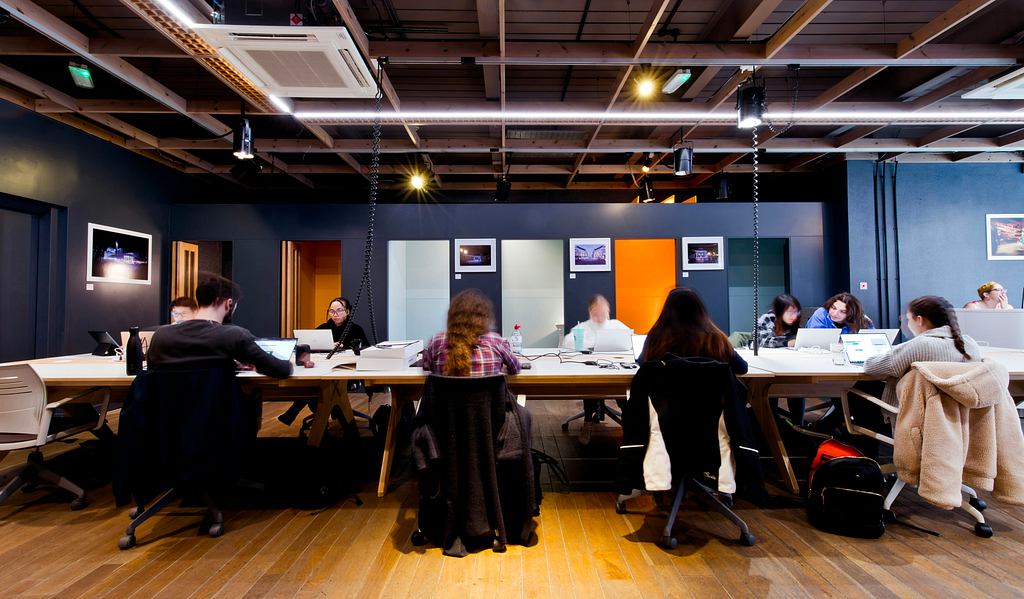 A group of people sitting around a table in an office space.