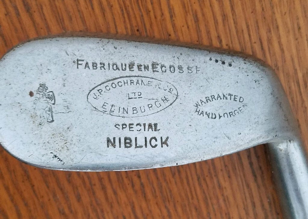 A picture of a forged iron golf club head with an inscription. Photo by author.