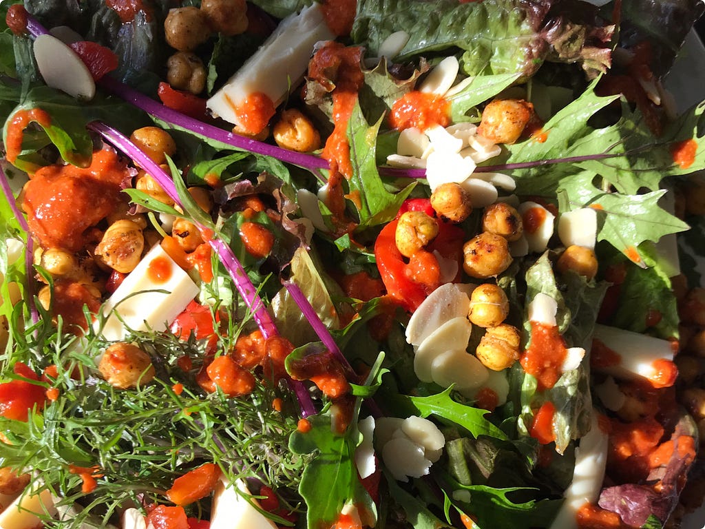 colorful salad with chickpeas, arugula, and roasted red pepper dressing