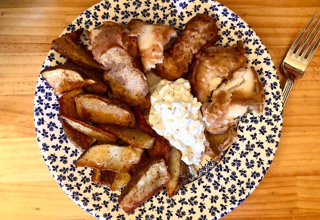 Fish and chips on a plate with homemade tartar sauce.