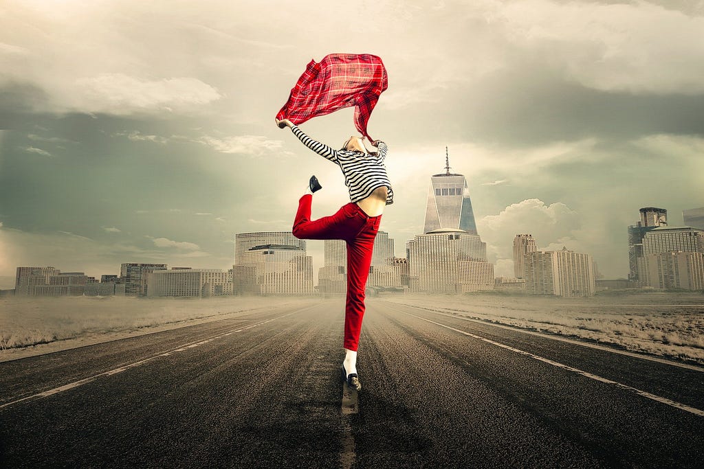 woman happy in red and dancing in the middle of the road