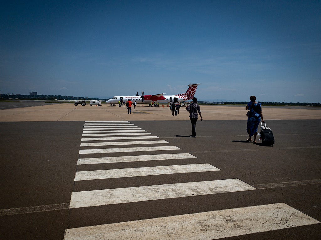 People walkinb on the tarmac to a plane.