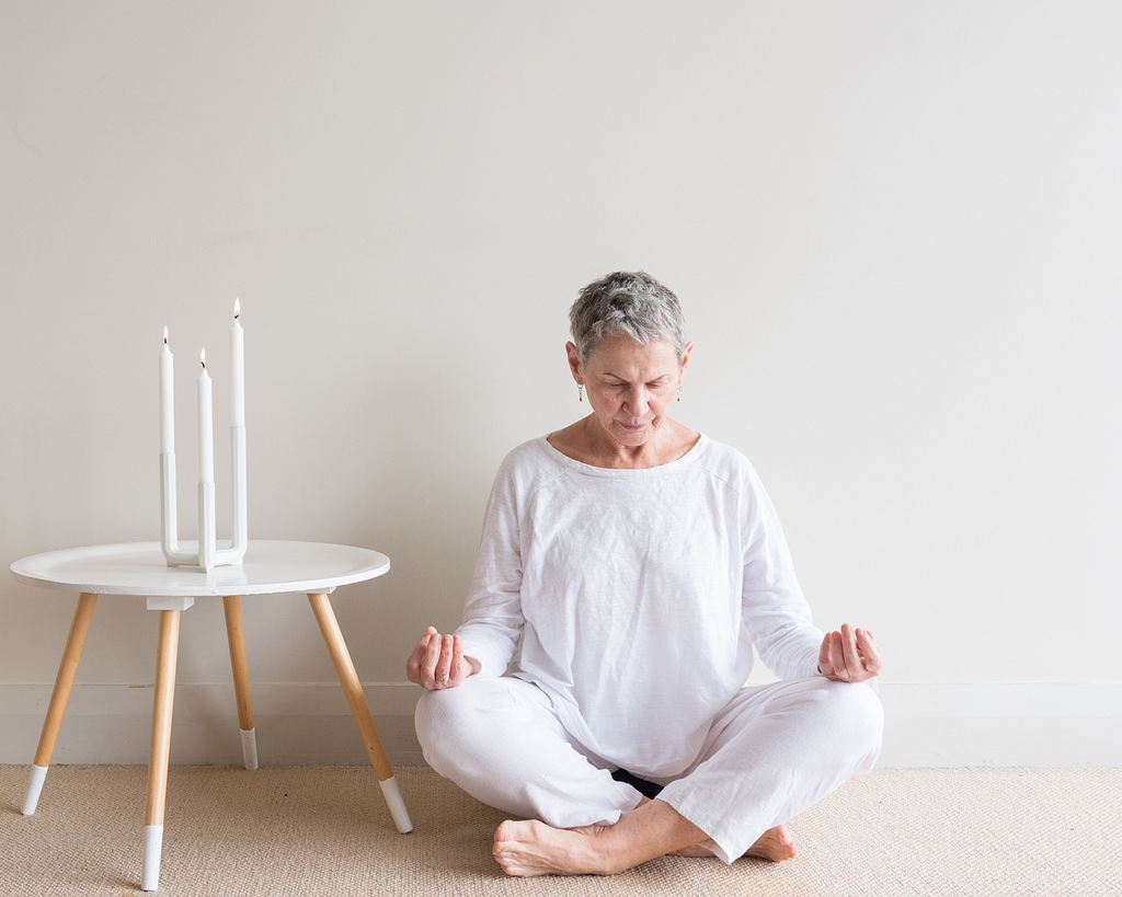 older woman sitting, meditating. Embracing Crone Wisdom: A New Chapter of Value and Insight