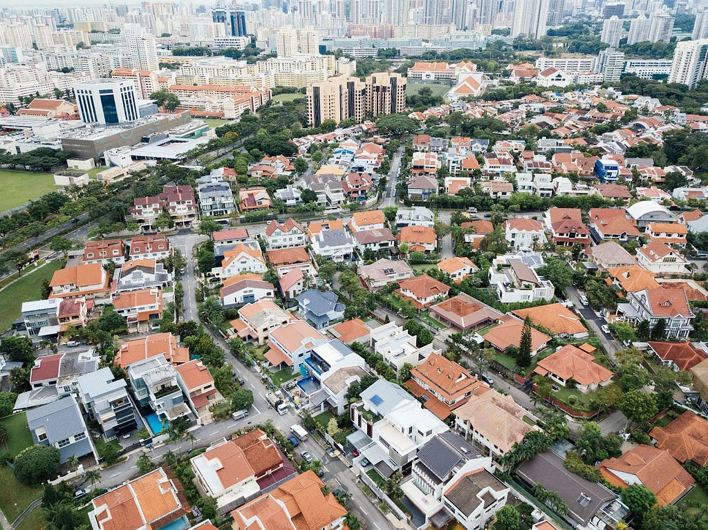 A mixed urban scene from a high level looking off into the distance. In the near ground is a tight suburban neighborhood. Further off are medium rise buildings. In the far distance, dense high rises fill the horizon. This shows the variety of land uses and how they are impacted by zoning.