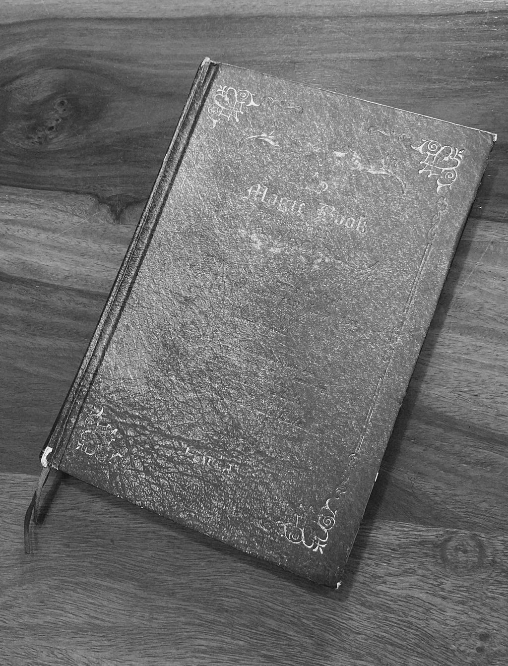 Grayscale picture of a notebook on a wooden table