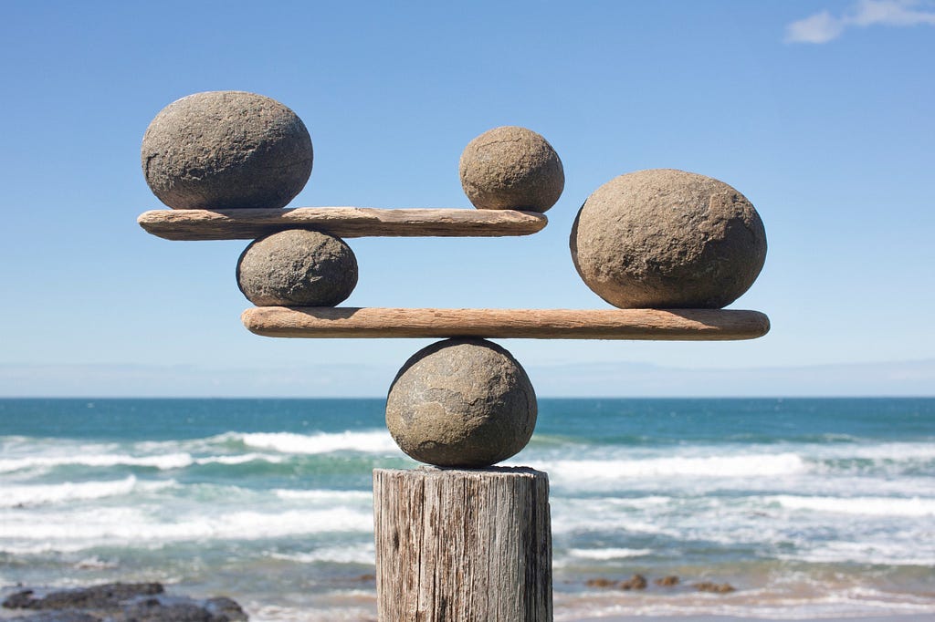 Rocks balanced on sticks on top of a rock.