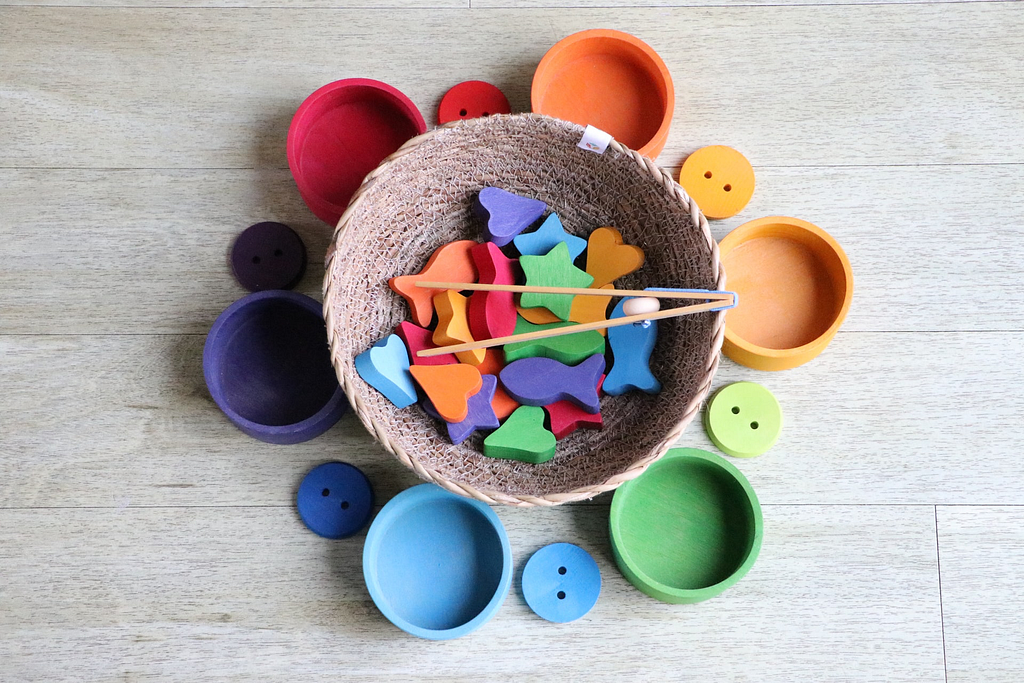 a basic filled with brightly colored shapes with chopsticks surrounded by brightly colored bowls and buttons