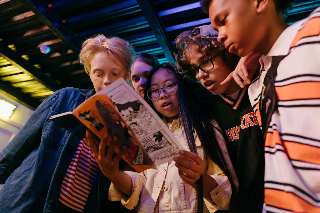 Five children reading a comic book together