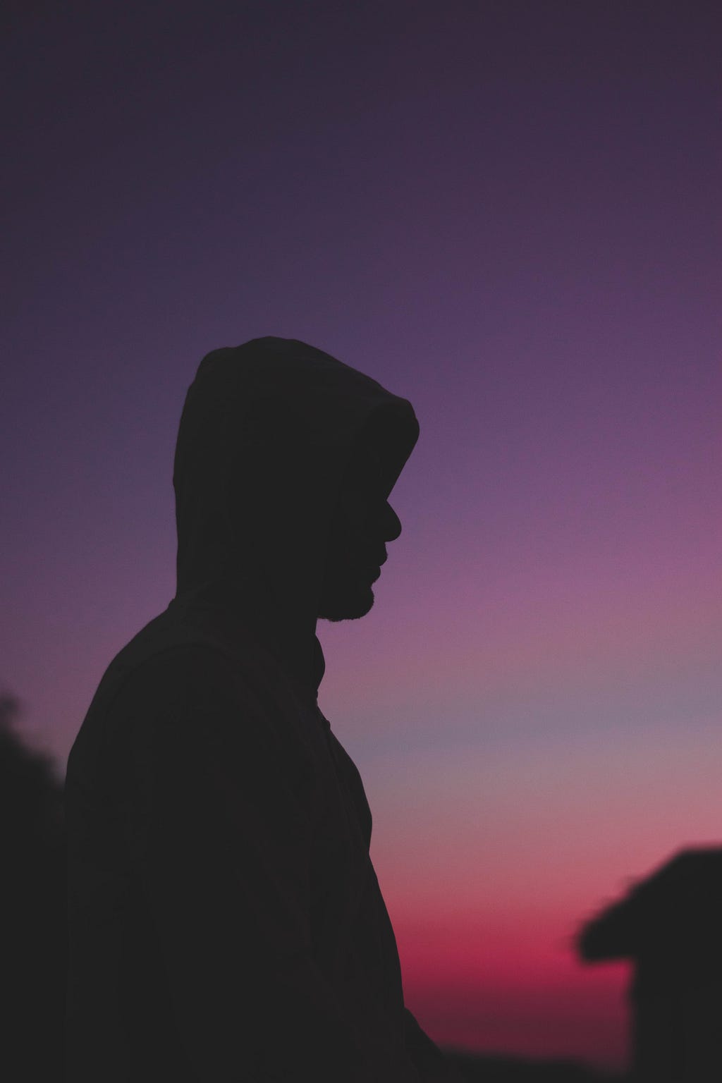 A person silhouetted against a sunset — photo by Dilan NaGi on Unsplash.