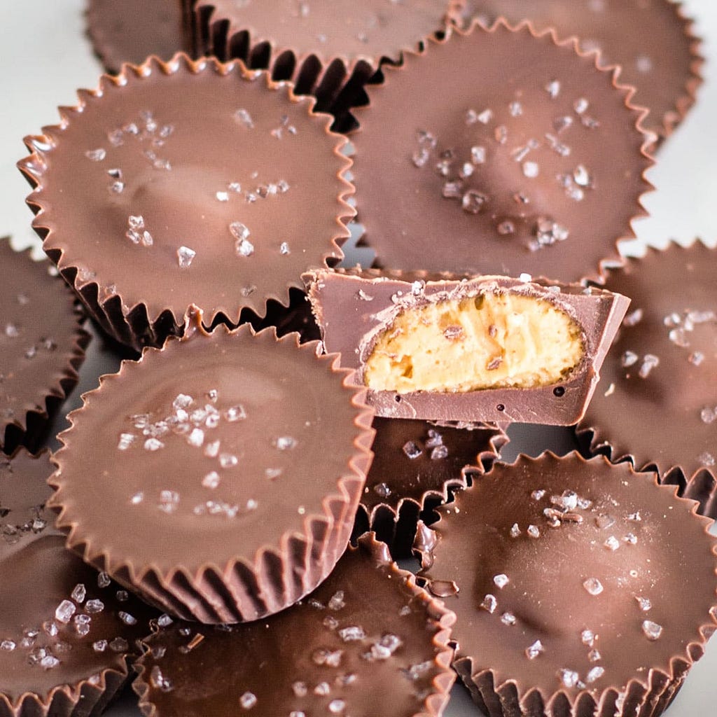 Closeup on many chocolate peanut butter cups topped with sea salt.