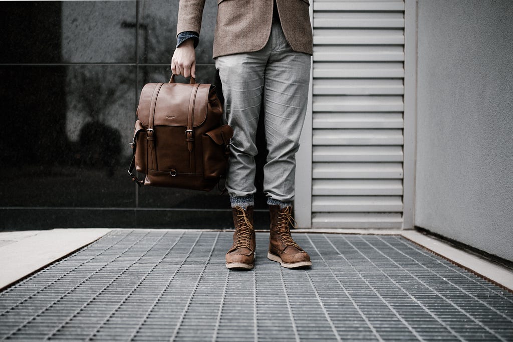 Man standing and waiting with a briefcase.