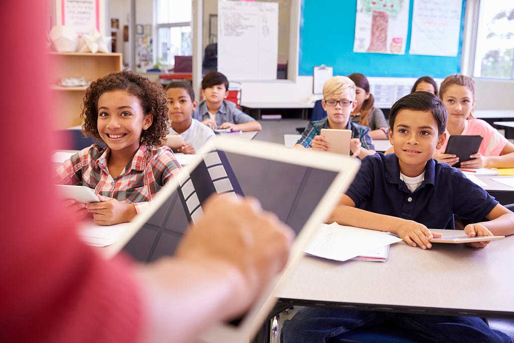 A teacher using a tablet computer in an elementary school lesson. Photo by monkeybusinessimages/Getty Images