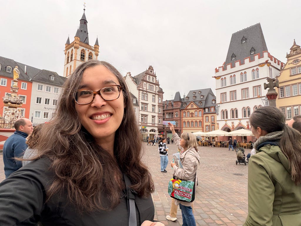 Amy smiling at the camera with several Roman and German buildings in the background.