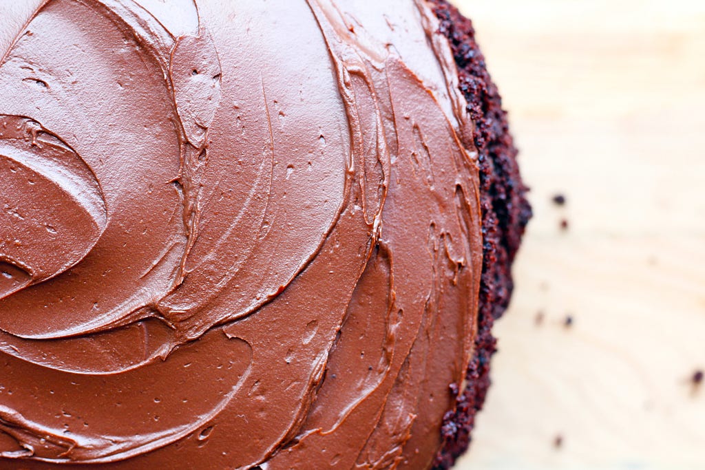 A rich chocolate cake with swirls of chocolate icing on top.