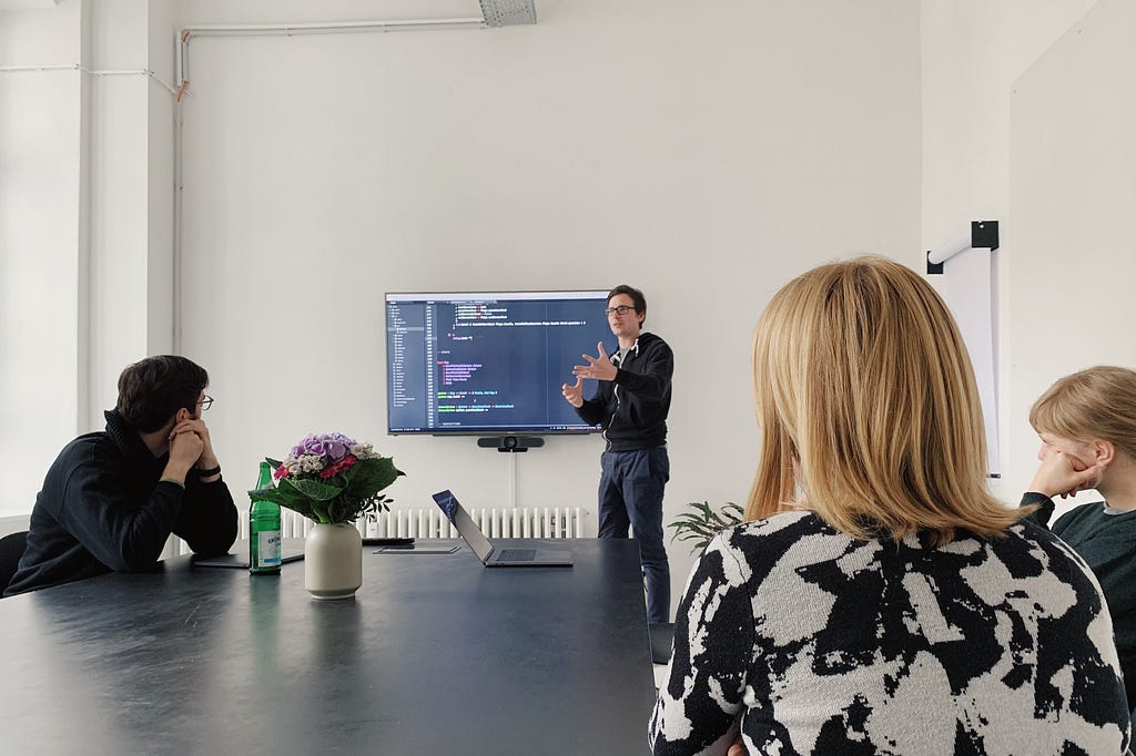 A developer giving a passionate speech about code to three colleagues.