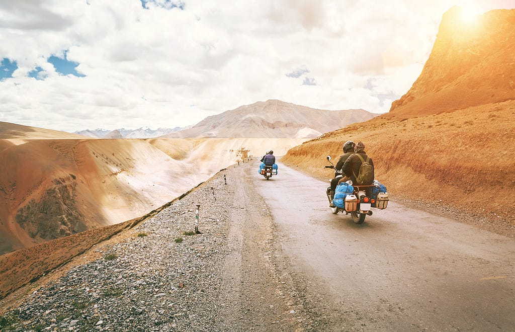 People driving on road on vespas.