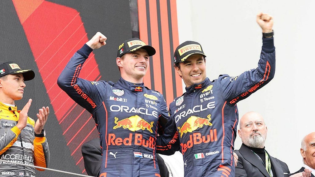Image of Red Bull F1 racers Max Verstappen and Sergio Perez celebrating a race result on the awards podium.