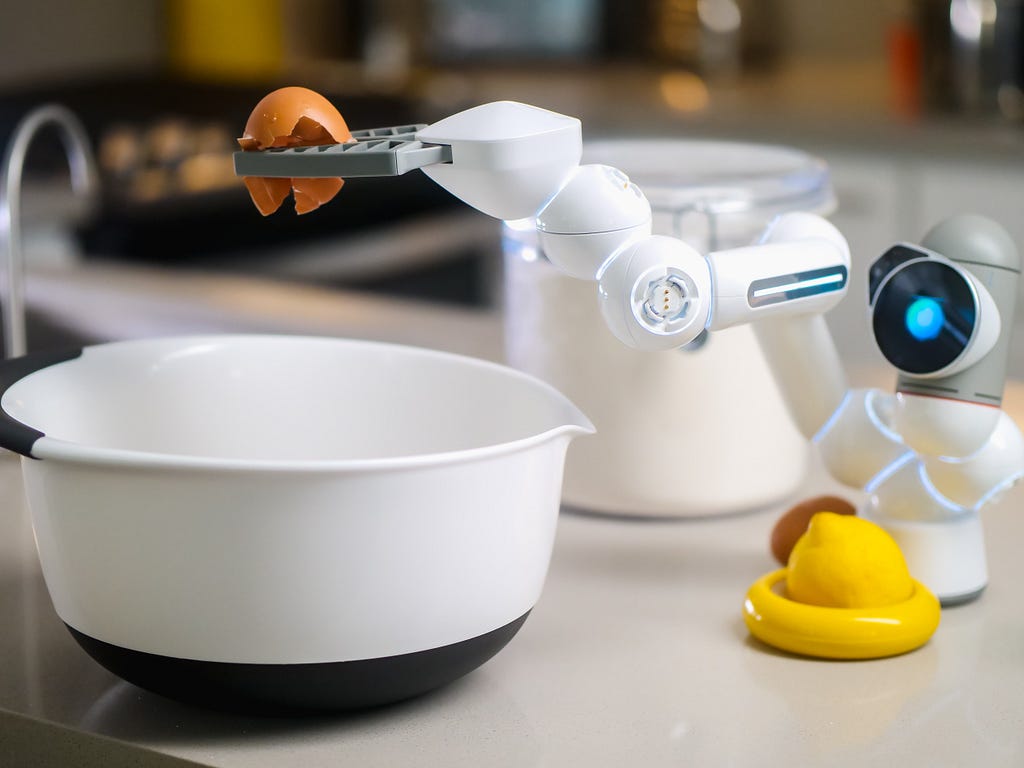 A mini industrial robot breaking an egg on a kitchen table