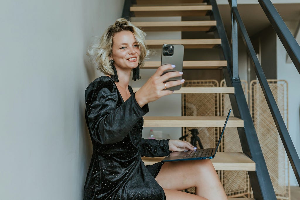 a woman in a black dress sitting on a stair case