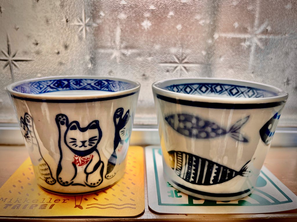 A pair of Japanese ceramic cups with cute animal (cat and fish) patterns