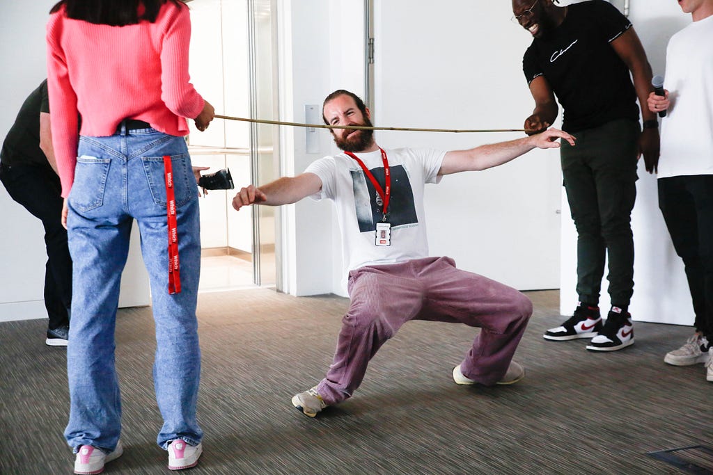 Man passing under a limbo stick as a part of a team building activity
