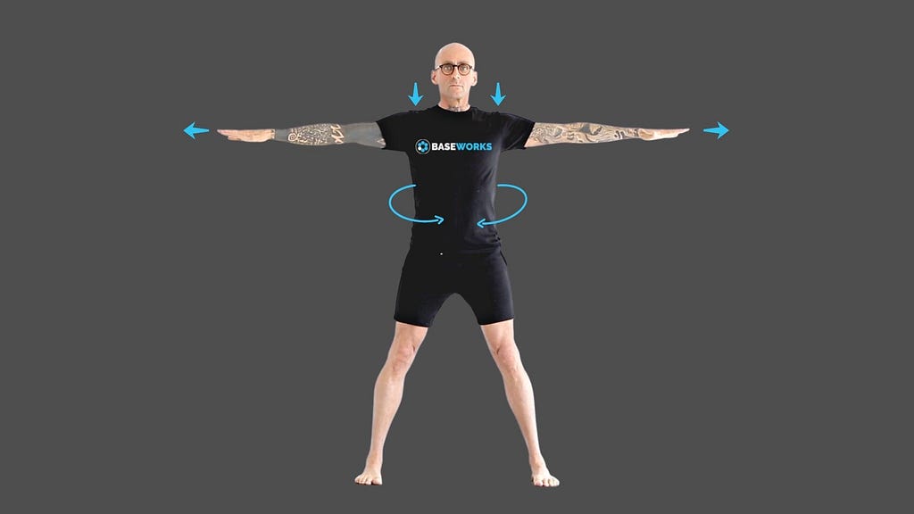 Photo of Patrick Oancia performing the movements explained in the TRY IT OUT section. He is standing upright with his feet apart wider than hips width and his arms extended to the sides.