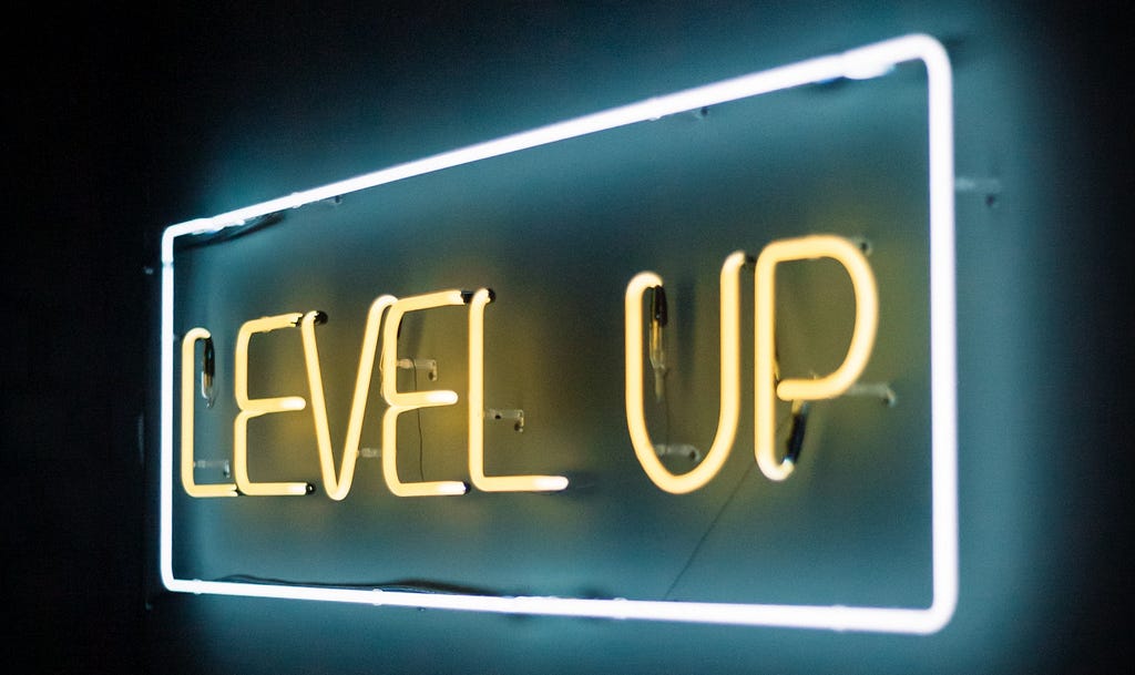 A neon sign saying ‘level up’ is shown. Level up is written in yellow neon lights