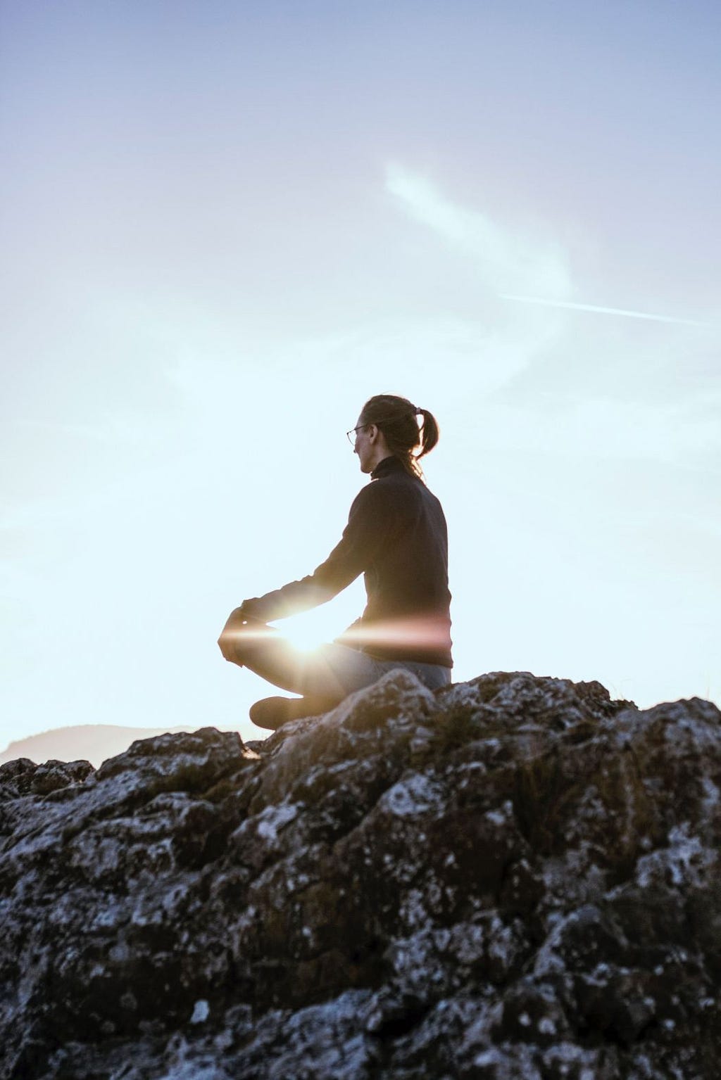 A woman meditating on a rock