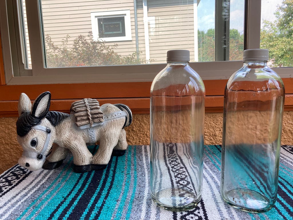 2 48-ounce bottles used for water, with a donkey for scale.