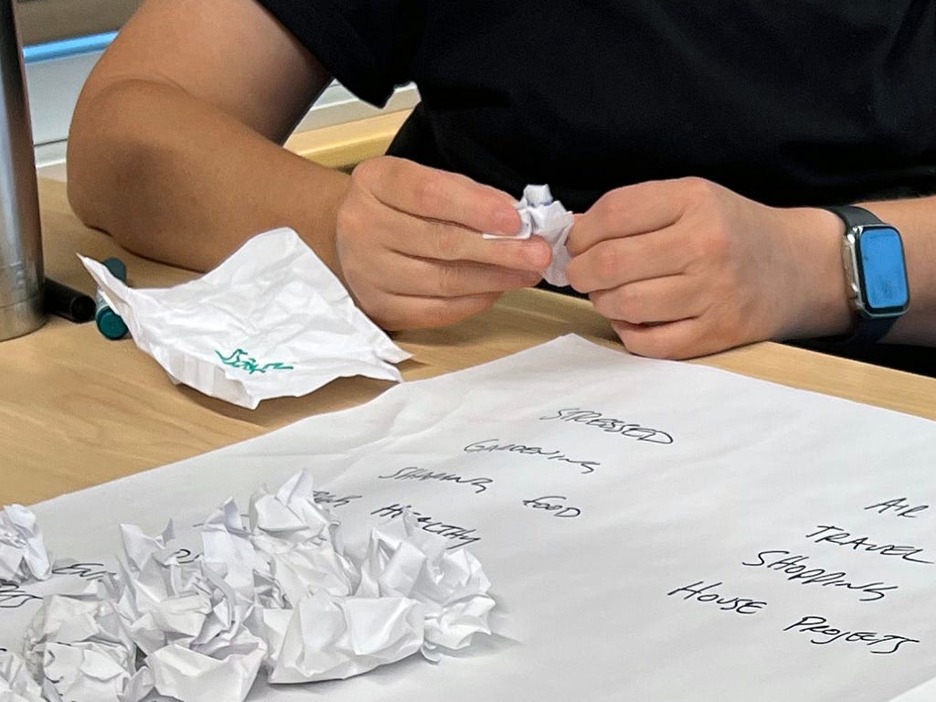 Photograph of Ashley unfolding some of the crumpled balls of paper we had gathered and reading the topics out loud.