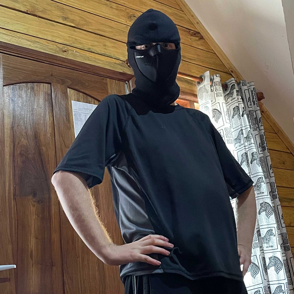 The author pictured inside a hut wearing a balaclava.