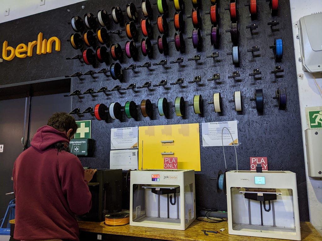 A wall full of spools of colorful PLA