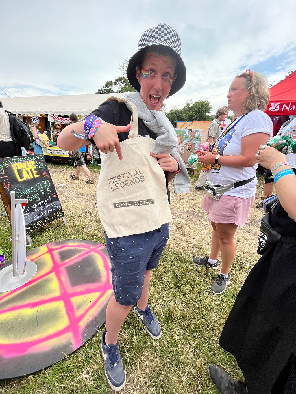 Person holding a bag and pointing to logo that says ‘Festival Legends’