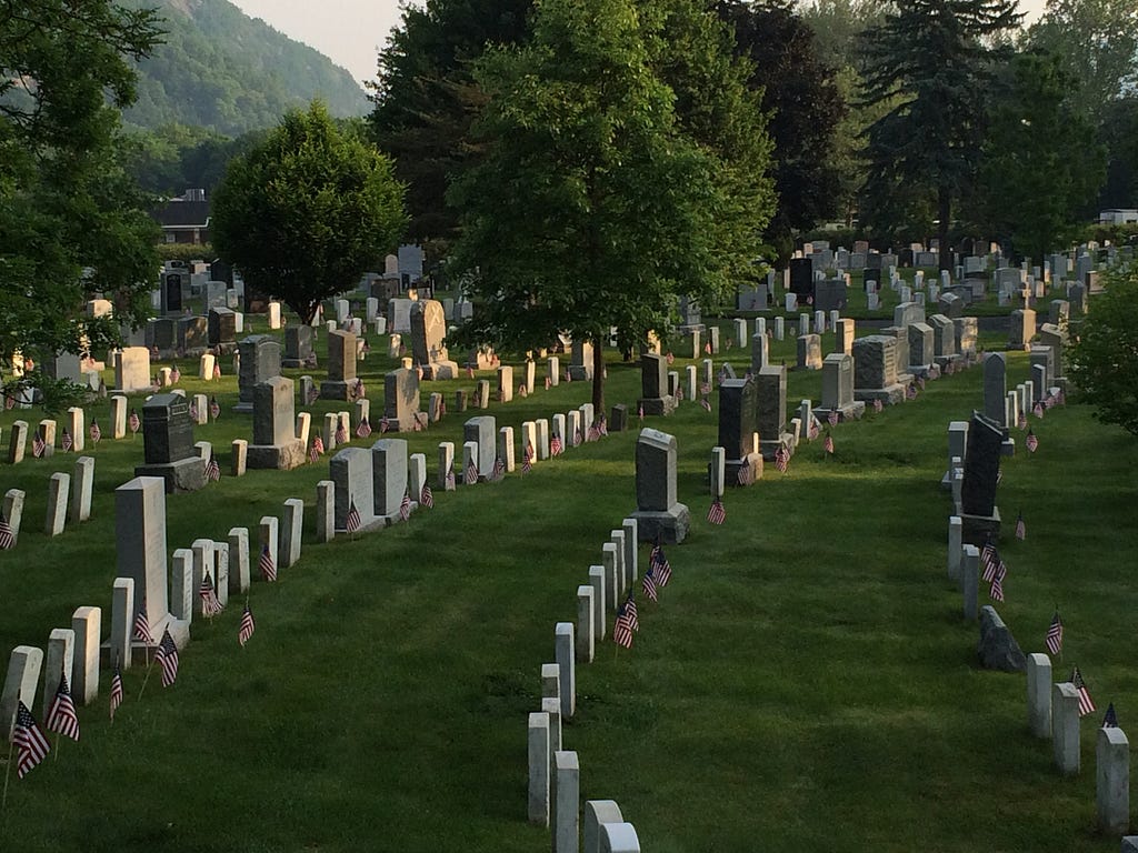 Headstones with small American flags at the cemetery of the United States Military Academy, West Point, on Memorial Day, 2016.