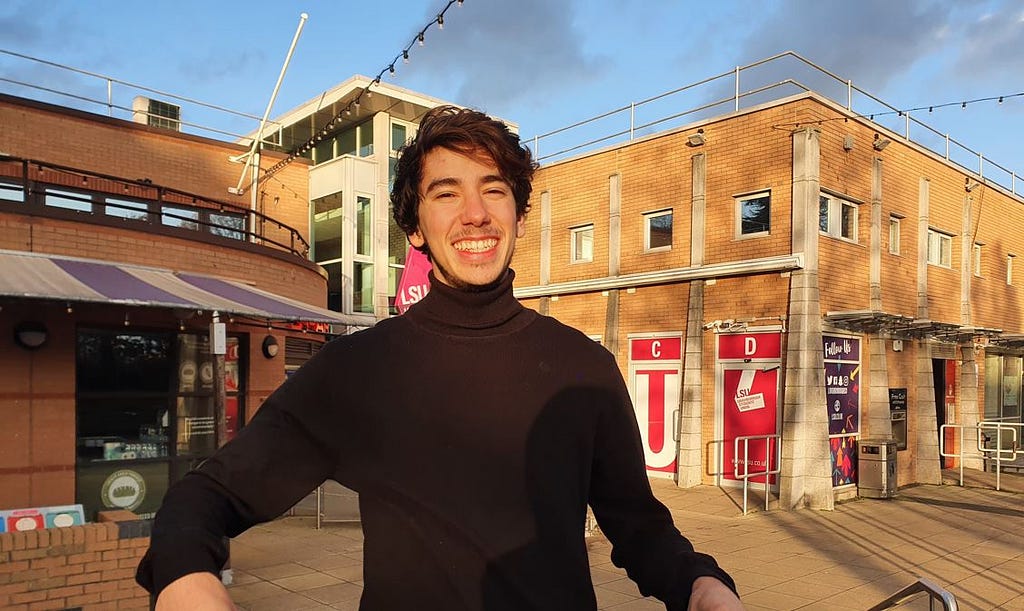 Smiling person on a sunny day with a turtle neck top